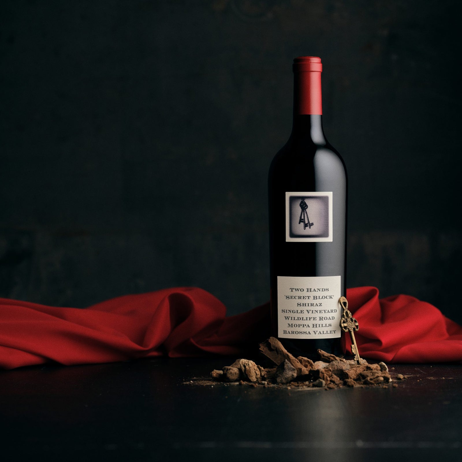 Bottle of Two Hands Secret Block Single Vineyard Shiraz wine with a red cap and a label that includes the brand name and the vineyard's location in the Barossa Valley.