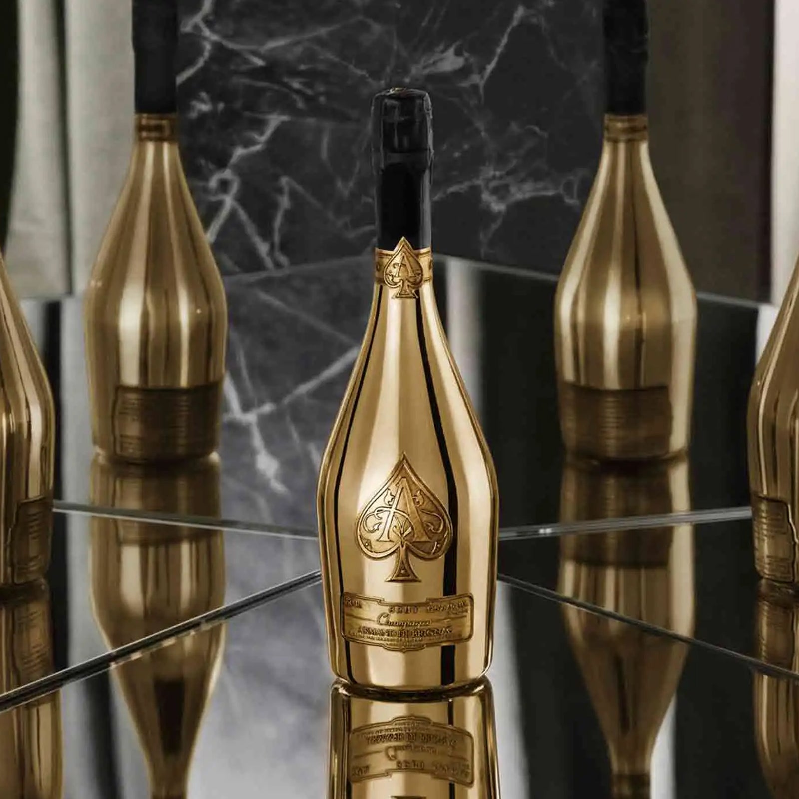 A luxurious bottle of Armand de Brignac "Ace of Spades" Brut Gold Champagne, 750ml, with its iconic metallic gold finish and pewter labels, displayed in a high-end setting to evoke a sense of celebration and opulence.