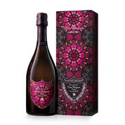 A bottle of Dom Pérignon Grand Cru Champagne next to its matching decorative packaging box, both featuring a vibrant magenta, pink, and dark red mandala pattern on a black background.
