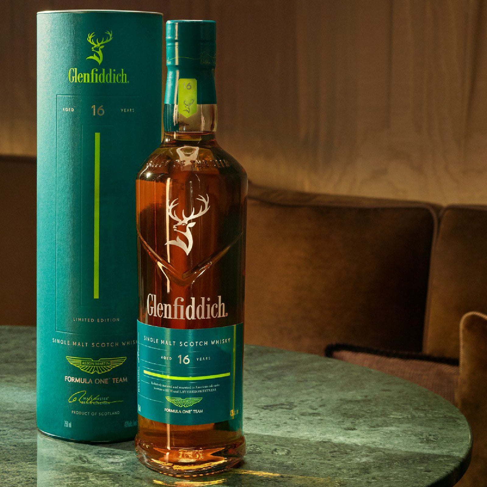 Glenfiddich 16-year-old whisky bottle and packaging on a table with a blurred background