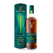 A bottle of Glenfiddich 16-year-old single malt Scotch whisky stands next to its matching dark green cylindrical packaging box on a clean white background.
