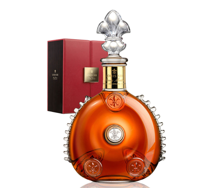 Luxury cognac bottle with decorative cap and red box on a white background