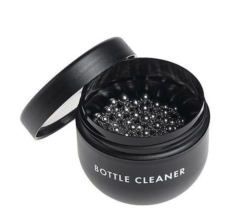 A black container, filled with small, round, silver cleaning beads.