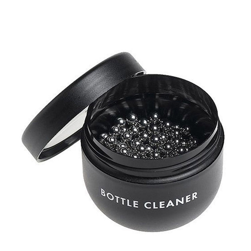 A black container, filled with small, round, silver cleaning beads.