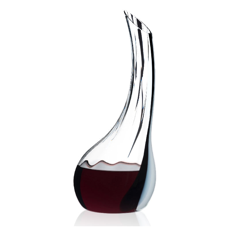 A Riedel handcrafted decanter made of optical blown glass with a black-white-black ornamental line, filled with red wine.