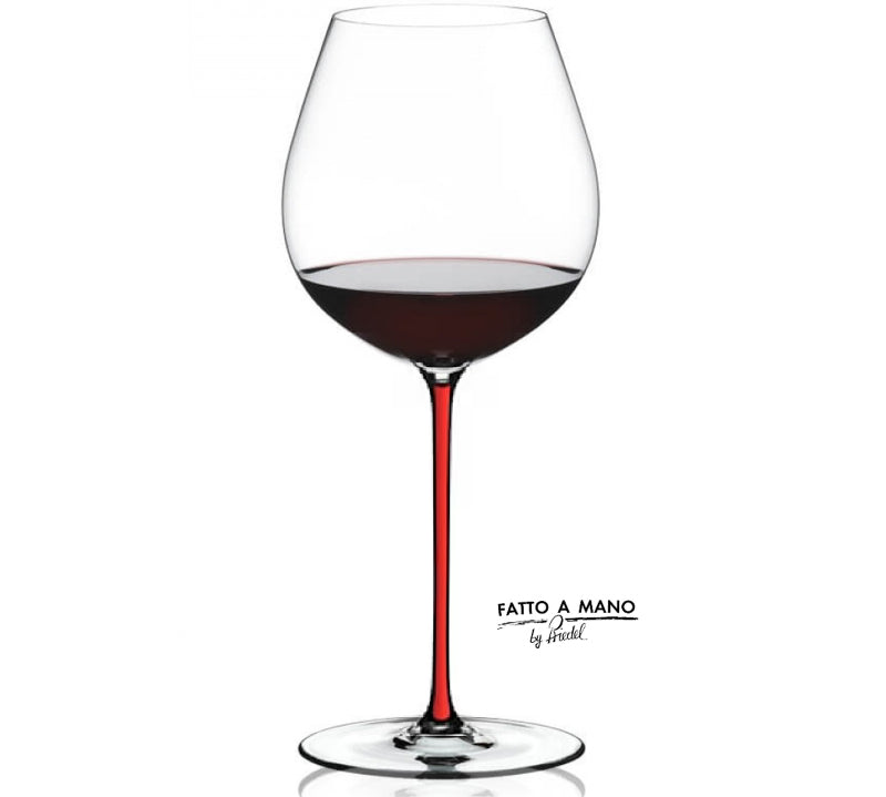 Wine glass with red wine and 'Fatto a Mano' branding on a white background