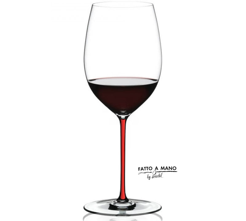 Wine glass with red wine and 'Fatto a Mano' branding on a white background
