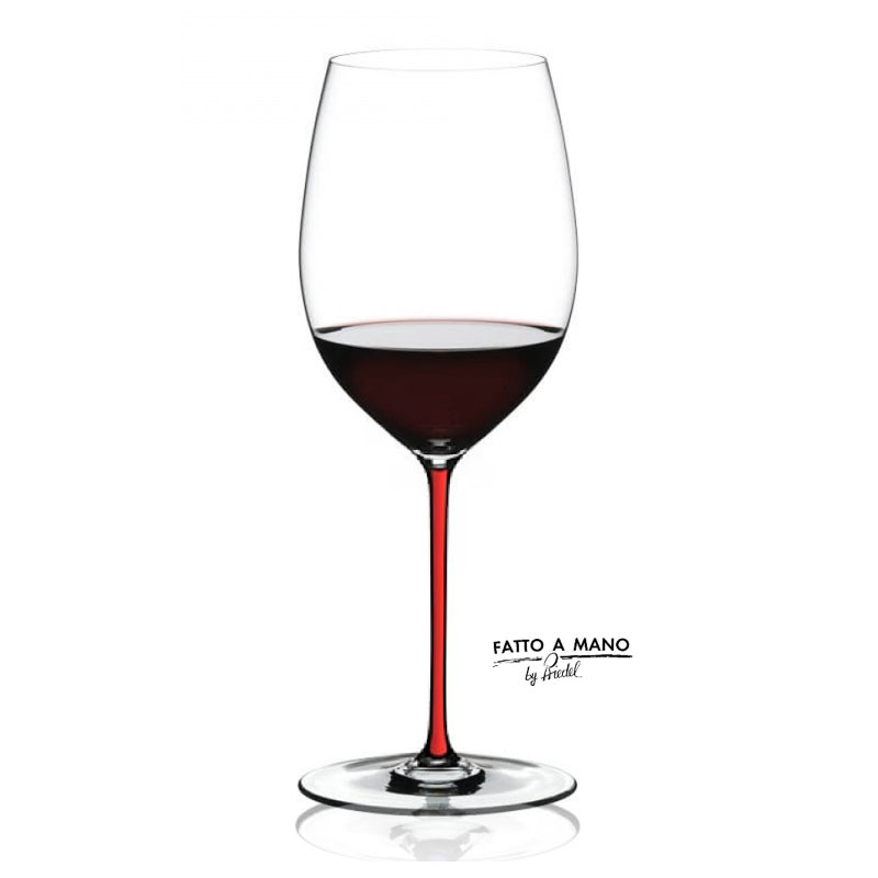 Wine glass with red wine and 'Fatto a Mano' branding on a white background