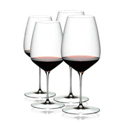 A set of four clear RIEDEL Veloce Cabernet Sauvignon wine glasses filled with red wine, showcasing their slender stems and rounded bowls.