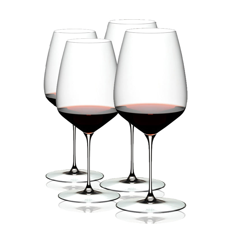A set of four clear RIEDEL Veloce Cabernet Sauvignon wine glasses filled with red wine, showcasing their slender stems and rounded bowls.