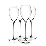 Four clear Riedel Veloce champagne glasses on a white background