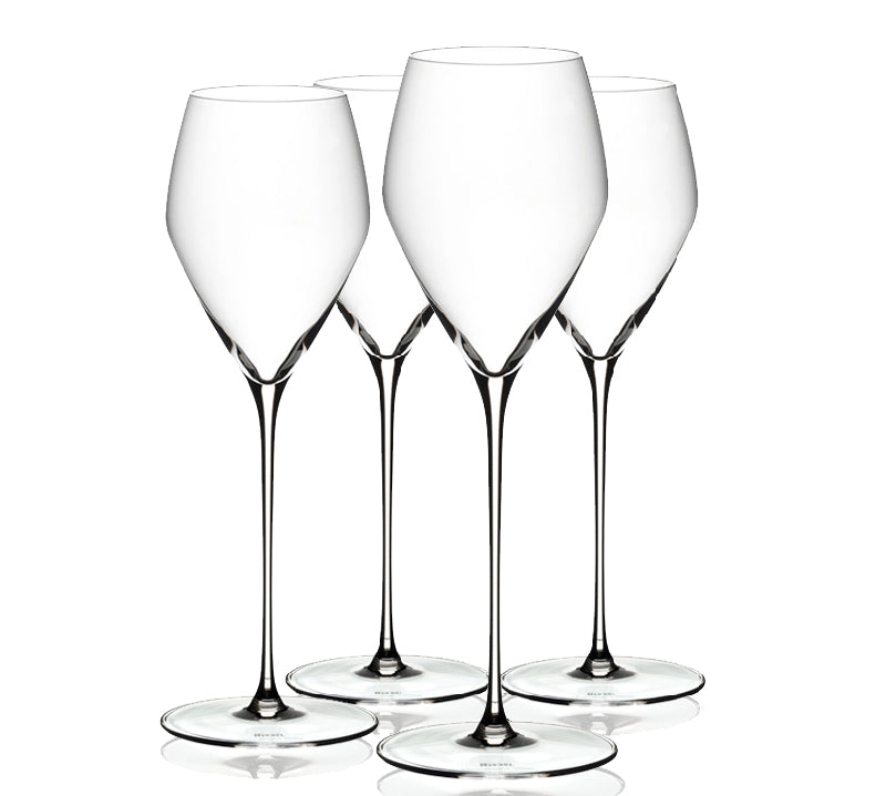 Four clear Riedel Veloce champagne glasses on a white background