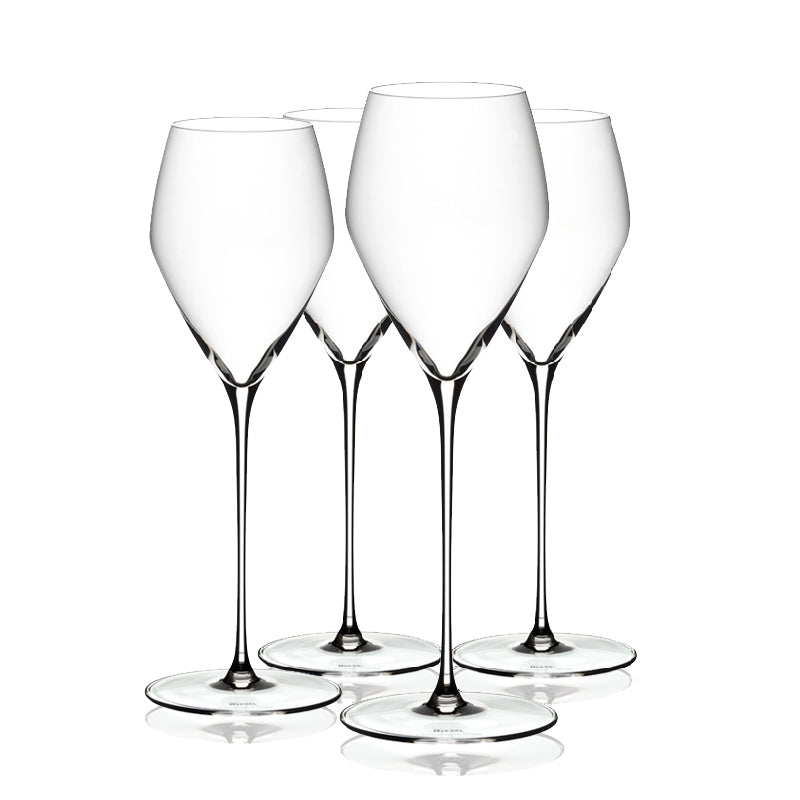 Four clear Riedel Veloce champagne glasses on a white background