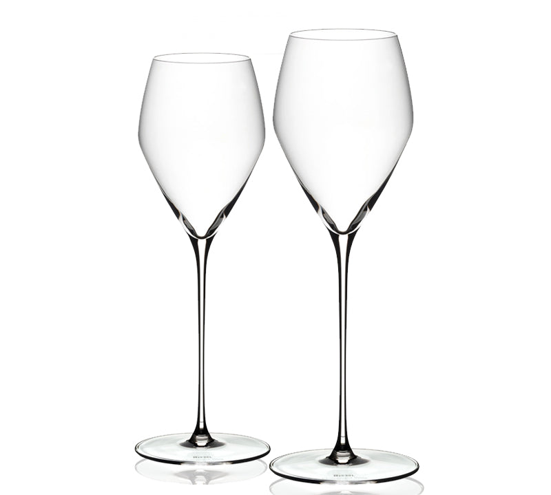 A set of two clear crystal RIEDEL Veloce champagne glasses with long stems and flared bowls, displayed against a white background.