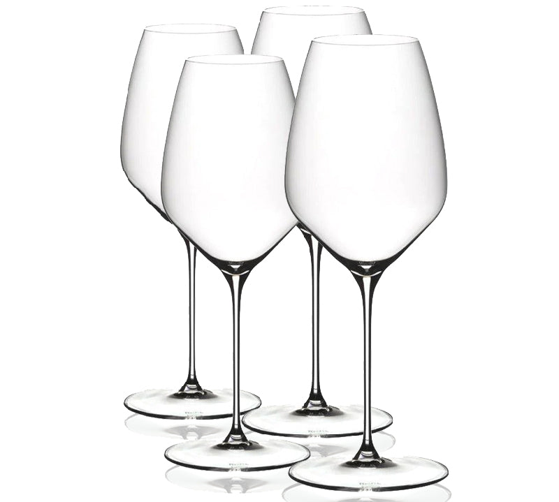 Four clear Riedel Veloce wine glasses on a white background