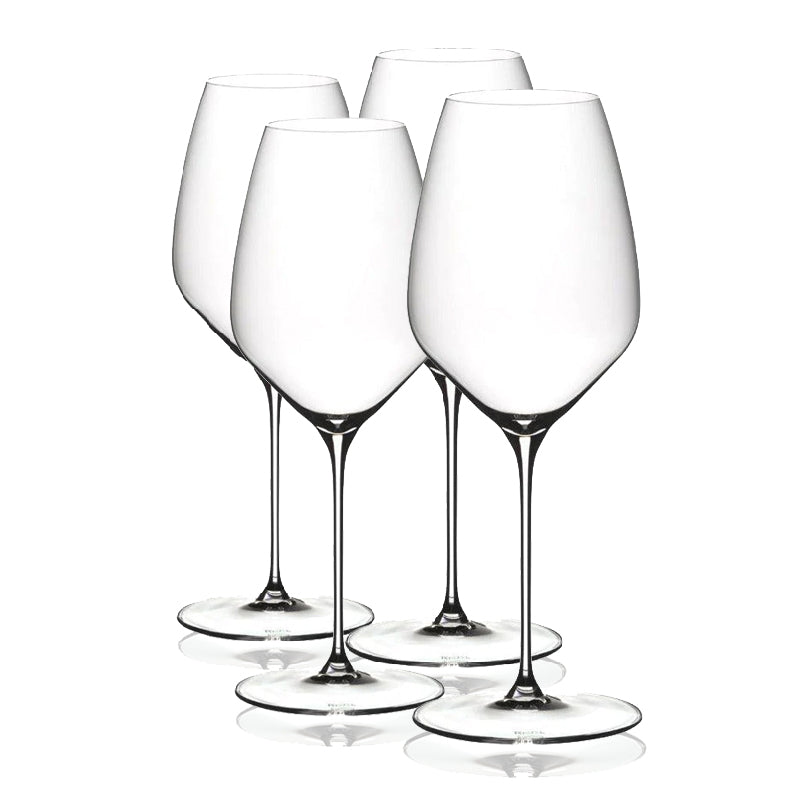 Four clear Riedel Veloce wine glasses on a white background