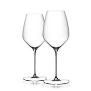 A set of two clear Riedel glasses with a tall and slender stem design, standing upright.