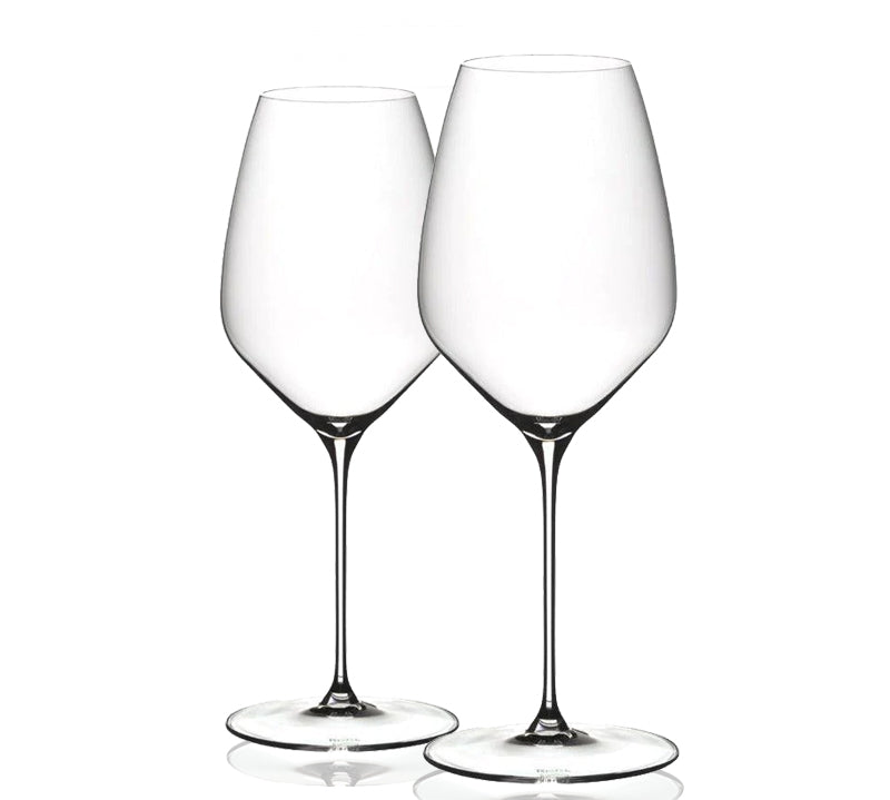 A set of two clear Riedel glasses with a tall and slender stem design, standing upright.