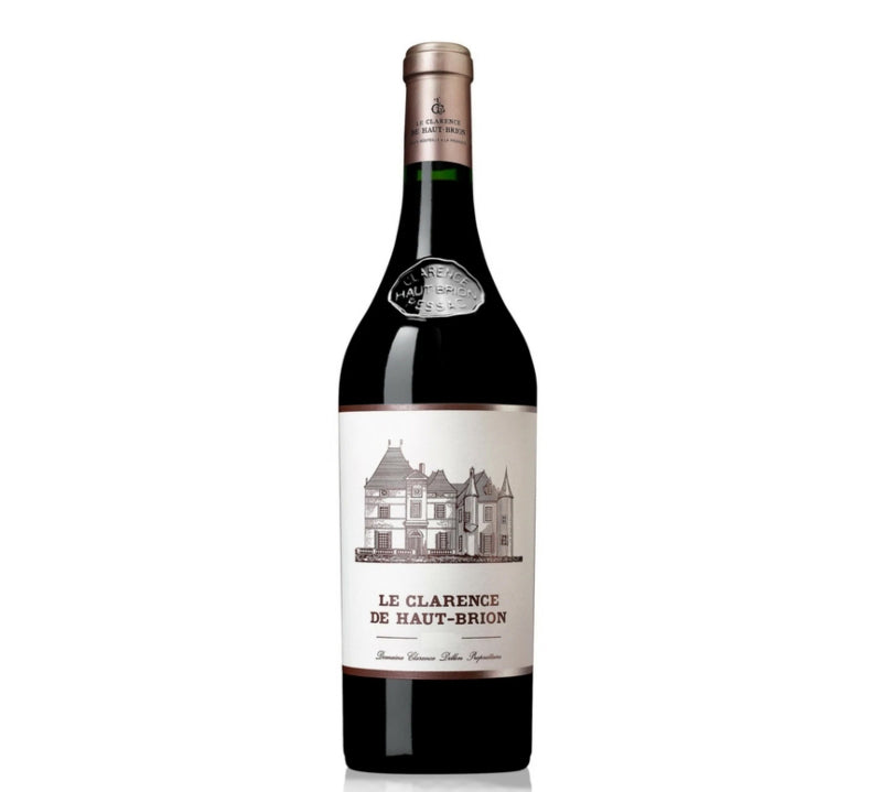 A bottle of Le Clarence De Haut-Brion Pessac-Leognan red wine with a label depicting the estate's chateau. The wine is in a clear bottle, showcasing a dark red liquid, with a cork closure.