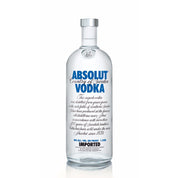 A clear glass bottle of Absolut Vodka with a blue label.